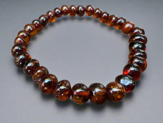 Beaded bracelet with amber-colored beads on a gray background