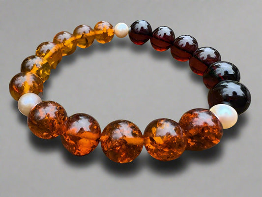 Beaded bracelet with amber and brown beads on a wooden surface
