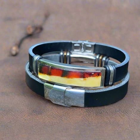 A two-tone, cognac and butterscotch amber, men's leather bracelet with a stainless steel clasp on a leather strap.