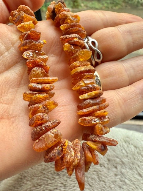 Amber necklace held in a hand with a blurred background