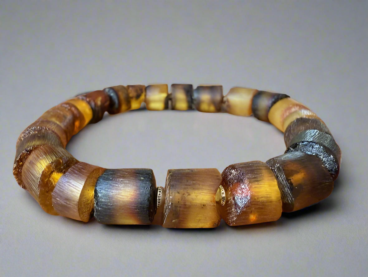 amber Bracelet with brown and silver beads on a light gray background