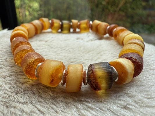 Beaded bracelet with amber and brown beads on a textured surface