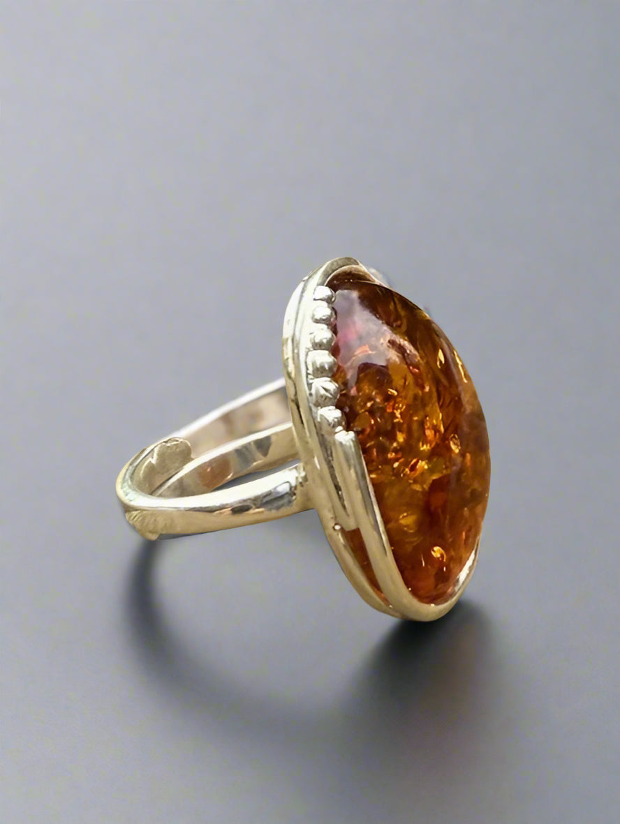 Ring with a large amber stone on a gray background