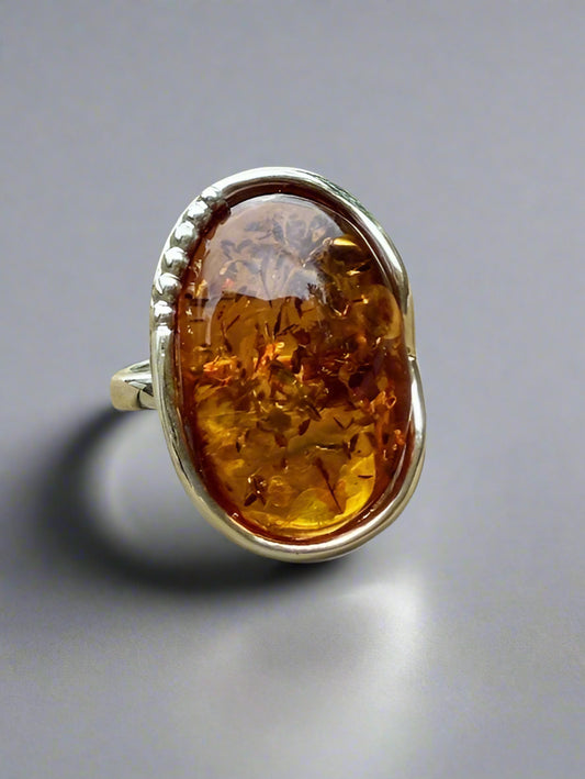 Ring with amber stone on a wooden surface