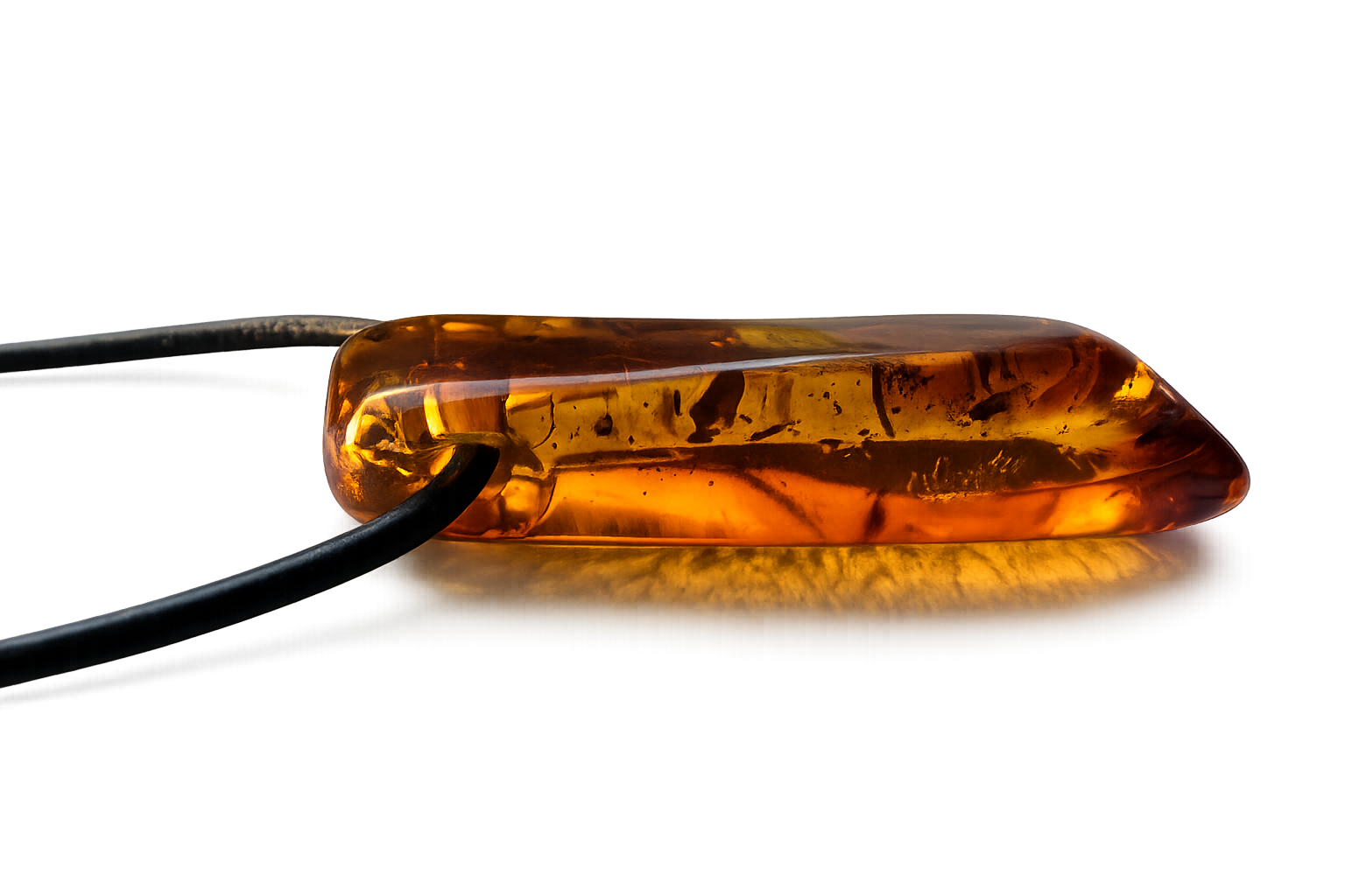 Amber-colored pill on a reflective surface with a dark background