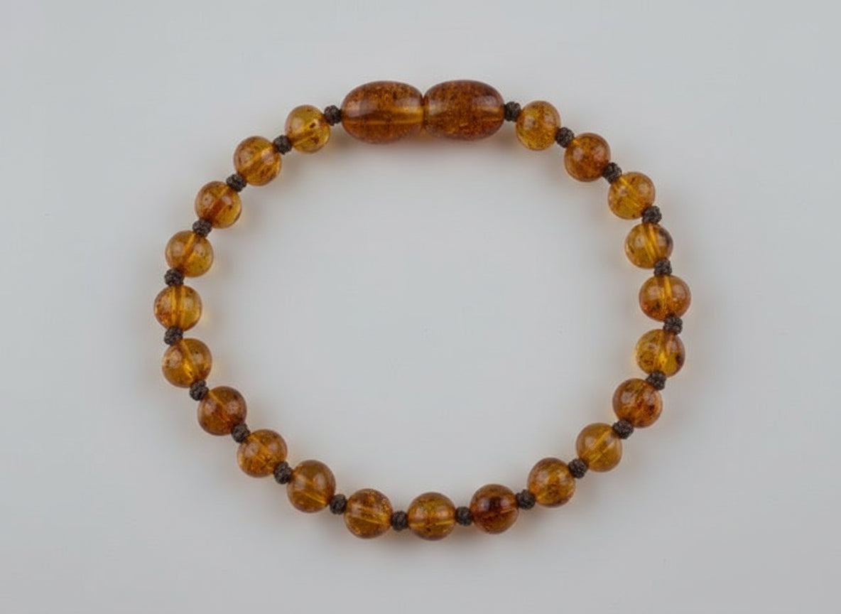 Beaded bracelet with amber-colored beads on a textured surface
